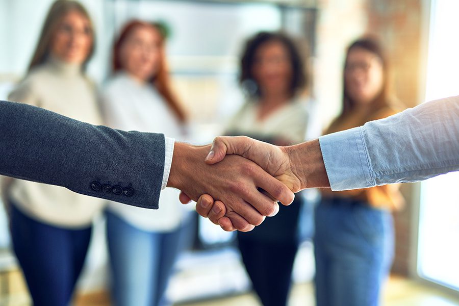 About Our Agency - Group of Business Workers Standing Together and Shaking Hands at the Hometown Insurance Services, LLC Office