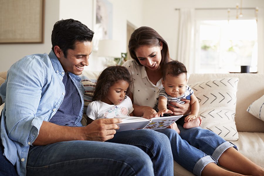 Blog - Family Reading a Book Together on the Sofa in Family Living Room